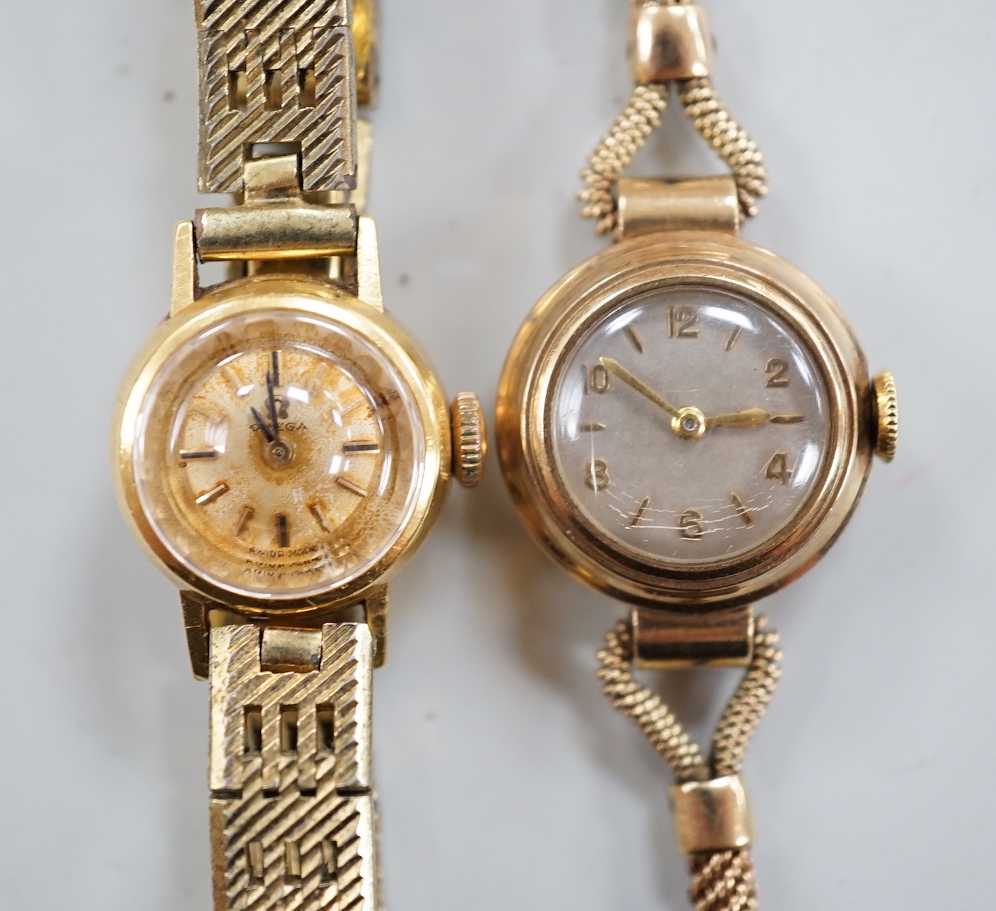 A lady's 9ct gold Omega manual wind wrist watch, on a gold plated bracelet, together with a lady's 9ct gold manual wind wrist watch, on a 9ct gold bracelet.